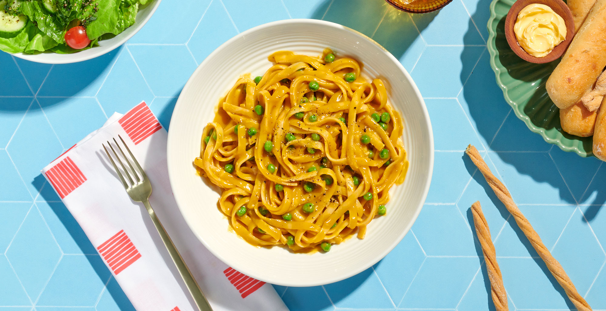 An image of prepared Vegan One Pot Butternut Alfredo made with Pacific Foods® Organic Creamy Butternut Squash Soup, Pacific Foods® Organic Vegetable Broth, fettuccine pasta and peas.