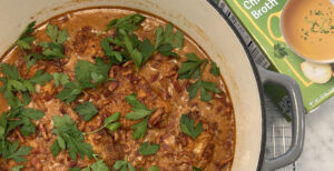 An image of prepared Creamy Paprika Chicken with Buttery Rice made with bacon, chicken thighs, Hungarian paprika, tomatoes, Pacific Foods® Organic Free Range Chicken Broth, white rice, dill, sour cream and parsley.