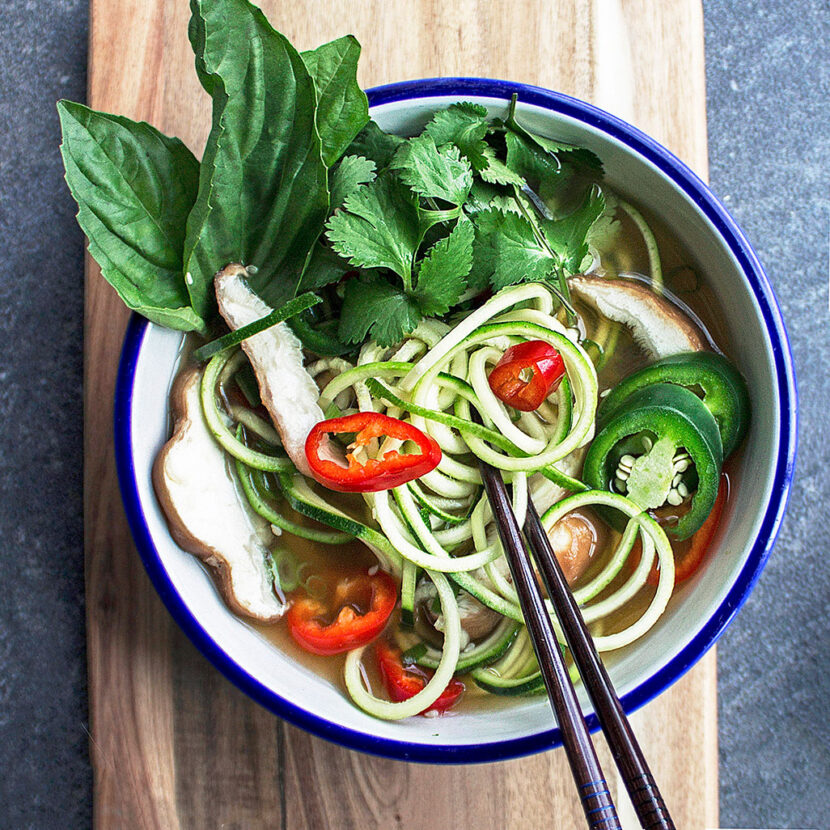 An image of prepared Pho Zucchini Noodle Soup made with Pacific Foods® Organic Mushroom Broth, garlic, lemongrass, ginger, mushrooms, jalapeño peppers, zucchini, basil and cilantro.