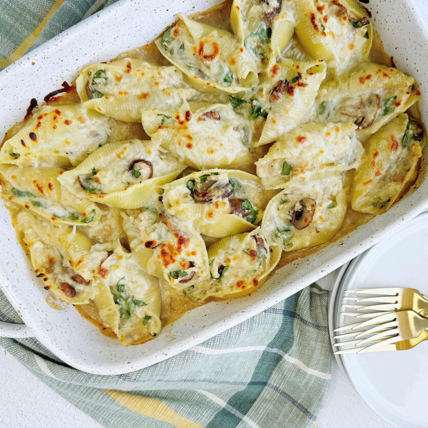 An image of prepared Chicken Alfredo Stuffed Shells with Mushrooms made with jumbo shells, mushrooms, ricotta cheese, Pacific Foods® Condensed Cream of Roasted Garlic & Herb Soup, Parmesan, mozzarella, chicken, baby spinach and Pacific Foods® Organic Chicken Stock.