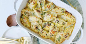 An image of prepared Chicken Alfredo Stuffed Shells with Mushrooms made with jumbo shells, mushrooms, ricotta cheese, Pacific Foods® Condensed Cream of Roasted Garlic & Herb Soup, Parmesan, mozzarella, chicken, baby spinach and Pacific Foods® Organic Chicken Stock.
