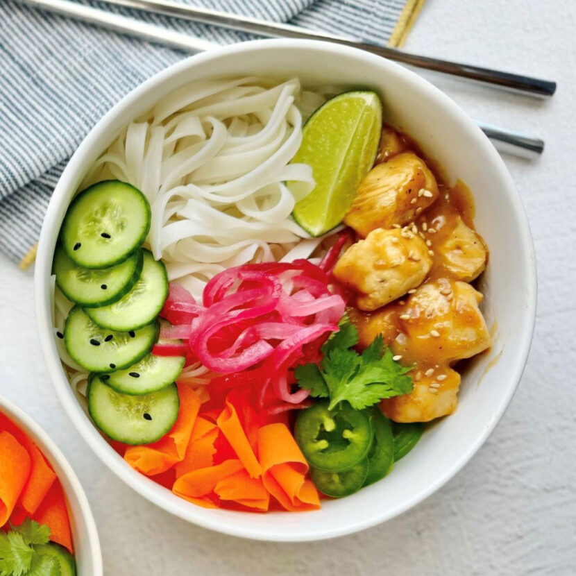 An image of prepared Gluten Free Banh Mi Chicken Bowls made with rice noodles, onion, chicken, Pacific Foods® Condensed Cream of Celery Soup, carrot, cucumber and cilantro.