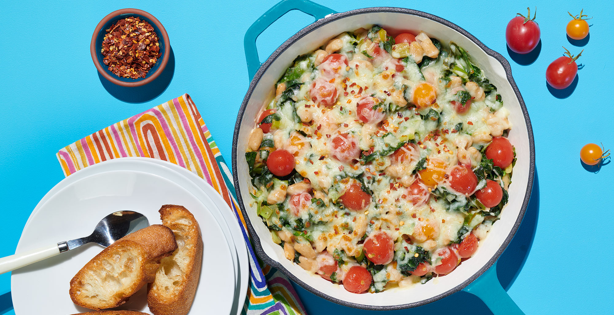 An image of prepared Garlic & Herb White Bean Dip made with leeks, kale, cherry tomatoes, white cannellini beans, Pacific Foods® Condensed Cream of Roasted Garlic & Herb Soup, Parmesan and mozzarella cheese.