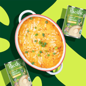 Summer dip recipe prepared in a dish next to cans of soup on a green background.