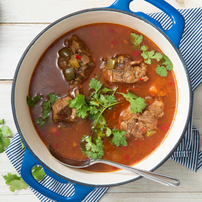 An image of prepared Caribbean Oxtail Stew made with beef oxtails, Pacific Foods® Low Sodium Organic Beef Broth, white rice, Pacific Foods® Low Sodium Organic Beef Broth, Pacific Foods™ Organic Unsweetened Plant-Based Beverage, pinto beans and cilantro.