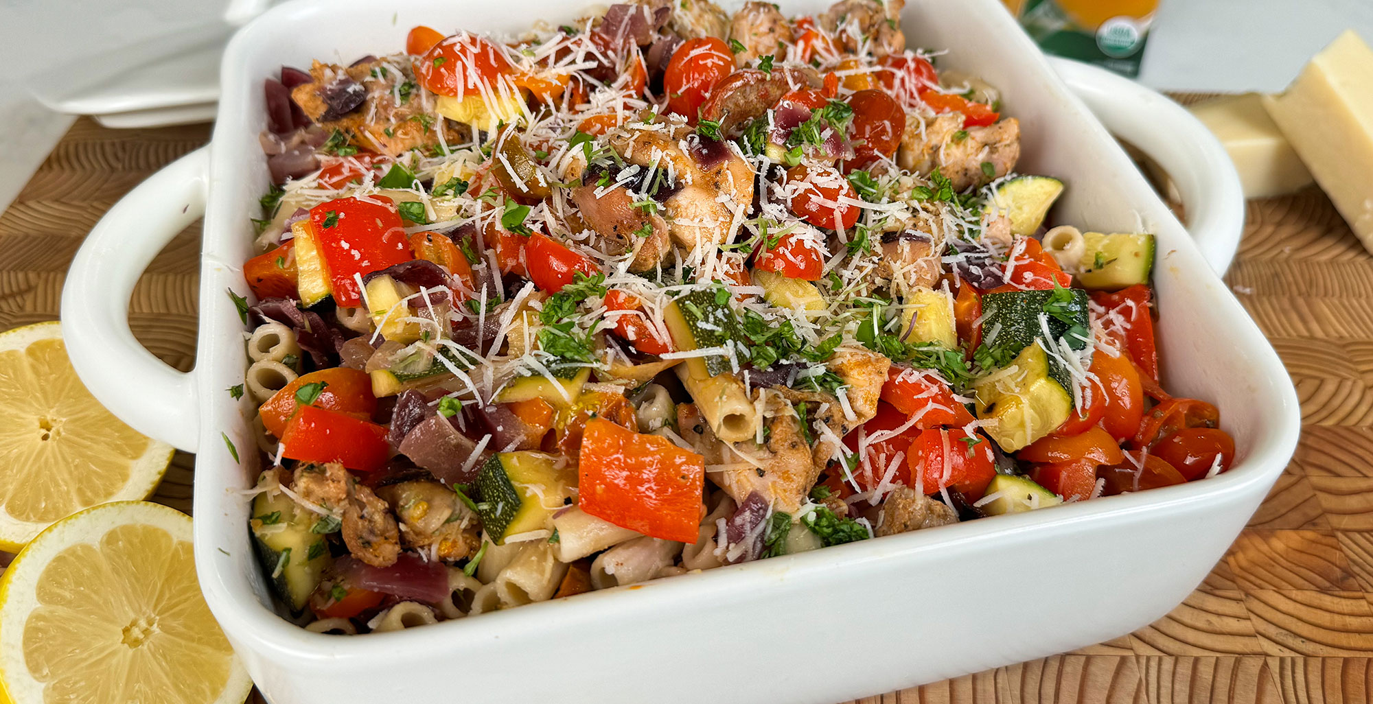 An image of prepared Gluten-Free Sheet Pan Honey Dijon Pasta made with zucchini, red onions, cherry tomatoes, chicken thigh, Pacific Foods® Free Range Chicken Broth and gluten free pasta.