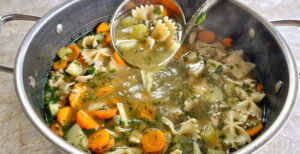 An image of prepared 30-Minute Chicken Noodle Soup made with Pacific Foods® Organic Free Range Chicken Broth, thyme, onion, carrots, parsnips, celery, rotisserie chicken and bowtie pasta.