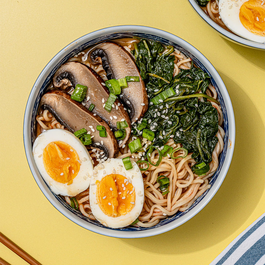 An image of prepared 15-Minute Spicy Red Miso Ramen made with Pacific Foods® Organic Free Range Chicken Broth, gochujang, white miso paste, ramen noodles, portobello mushrooms, spinach and egg.