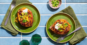 An image of prepared Turkey & Quinoa Chili-Stuffed Sweet Potatoes made with sweet potatoes, ground turkey, onion, poblano, Pacific Foods® Organic Chicken Bone Broth, tomato sauce, quinoa, black beans, and kidney beans.