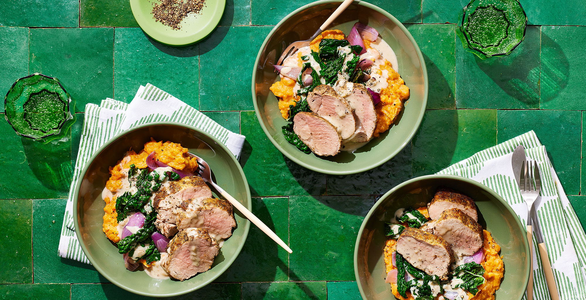 An image of prepared Garlic Herb Pork Tenderloin with Creamy Sweet Potato Mash made with sweet potatoes, pork tenderloin, onion Tuscan kale, Pacific Foods Condensed Cream of Roasted Garlic & Herb Soup and Pacific Foods® Organic Low Sodium Free Range Chicken Broth.