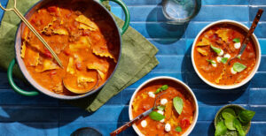 An image of prepared Hearty Lasagna Soup with Red Wine and Fresh Mozzarella made with yellow onion, tomato paste, garlic, Italian pork sausage, Pacific Foods® Organic Vegetable Broth, Pacific Foods™ Organic Cream Tomato Basil Soup, canned diced tomatoes, lasagna noodles, fresh mozzarella and basil.