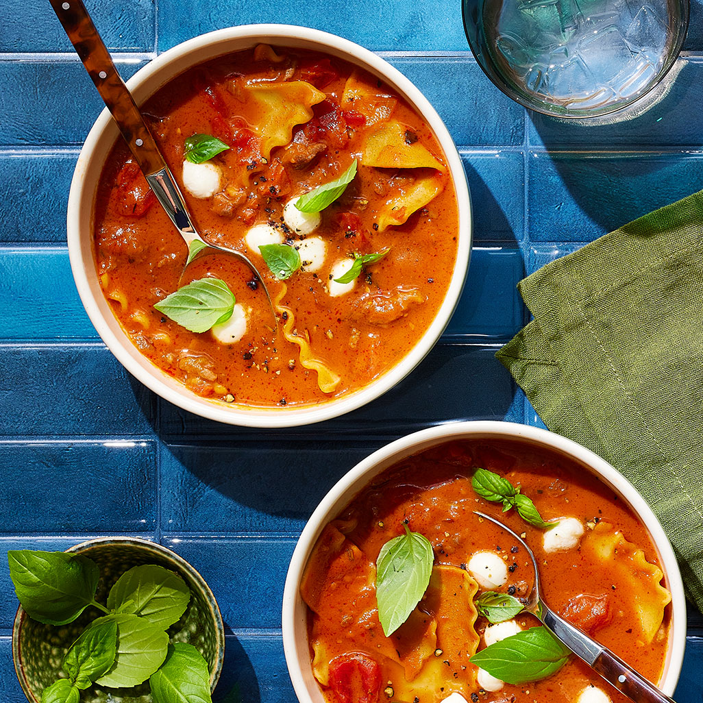An image of prepared Hearty Lasagna Soup with Red Wine and Fresh Mozzarella made with yellow onion, tomato paste, garlic, Italian pork sausage, Pacific Foods® Organic Vegetable Broth, Pacific Foods™ Organic Cream Tomato Basil Soup, canned diced tomatoes, lasagna noodles, fresh mozzarella and basil.