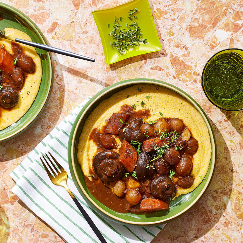 An image of prepared Mushroom Bourguignon & Creamy Parmesan Polenta made with cremini mushrooms, pearl onions, carrots, red wine, Pacific Foods® Organic Low Sodium Vegetable Broth, polenta, cream and Parmesan.