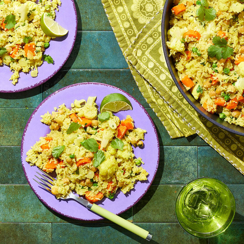 An image of prepared One-Pot Curry Bake made with onion, ginger, curry, coriander, basmati rice, Pacific Foods® Organic Chicken Bone Broth with Sea Salt, Pacific Foods™ Organic Unsweetened Plant-Based Beverage, carrots, garbanzo beans, peas and cilantro.