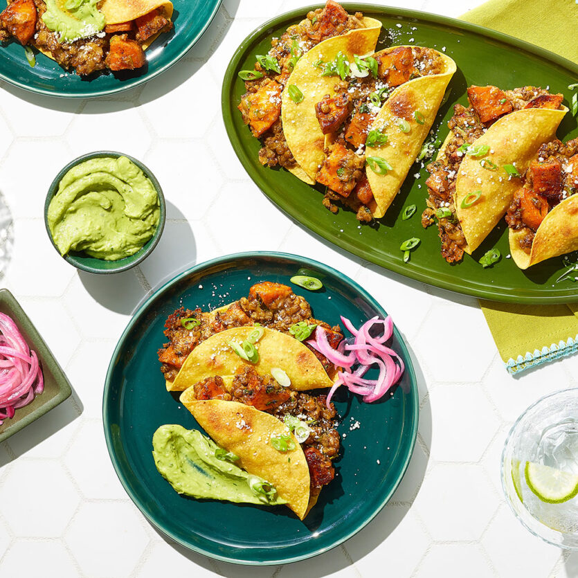 An image of prepared Sweet Potato and Lentil Tacos made with brown lentils, Pacific Foods® Organic Low Sodium Vegetable Broth, sweet potatoes, pepper Jack cheese, sour cream, cilantro, corn tortillas and avocado.