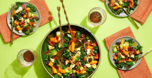 An image of prepared Warm Kale Salad with Butternut Dressing & Bacon made with bacon, butternut squash, kale, Brussels sprouts, Pacific Foods® Organic Creamy Butternut Squash Soup, maple syrup, Cheddar cheese, dried cherries and pecans.