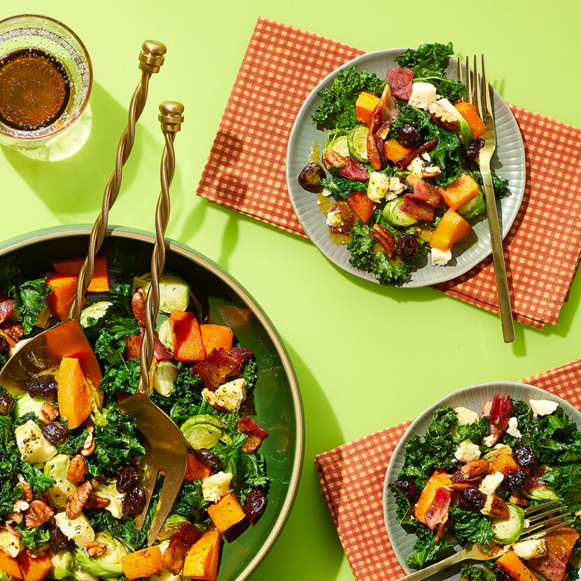An image of prepared Warm Kale Salad with Butternut Dressing & Bacon made with bacon, butternut squash, kale, Brussels sprouts, Pacific Foods® Organic Creamy Butternut Squash Soup, maple syrup, Cheddar cheese, dried cherries and pecans.