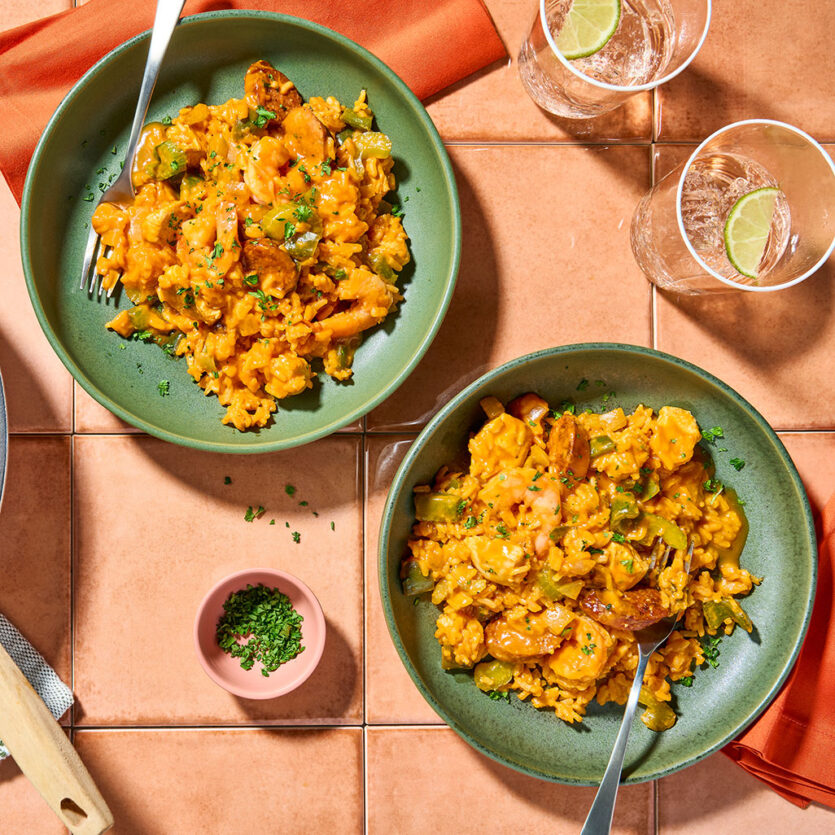 An image of prepared Creamy One-Pot Risotto-Style Jambalaya made with chicken, Cajun seasoning, andouille sausage, white rice, Pacific Foods® Organic Low Sodium Free Range Chicken Broth, Pacific Foods® Organic Spicy Garden Tomato Soup and shrimp.