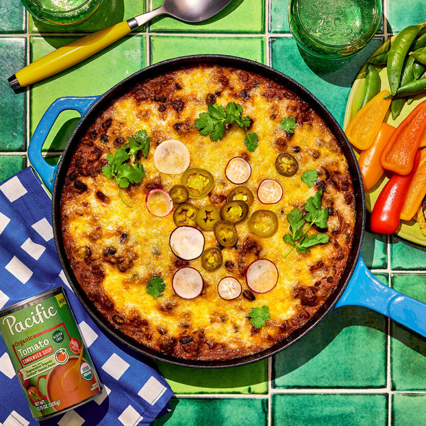 An image of prepared Beef Enchilada Dip made with ground beef, taco seasoning, garlic, Pacific Foods® Organic Condensed Tomato Soup, black beans, cream cheese and Mexican blend cheese.