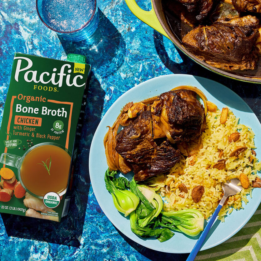 An image of prepared Beef Short Rib Adobo with Sinangag (Filipino Garlic Fried Rice) made with beef short ribs, onion, garlic, soy sauce, Pacific Foods® Organic Chicken Bone Broth with Ginger, Turmeric and Black Pepper and jasmine rice.