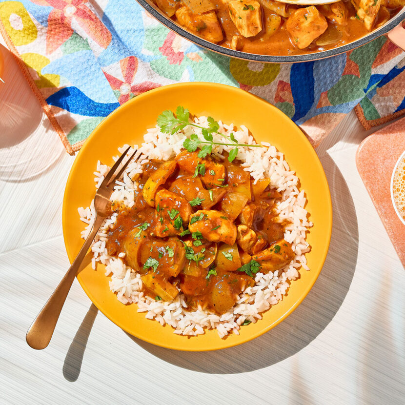 An image of prepared Caribbean Coconut Chicken with Rice made with rice, chicken, onion, bell pepper, jalapeño pepper, Pacific Foods® Organic Condensed Tomato Soup and Pacific Foods® Organic Coconut Unsweetened Organic Beverage and cilantro.