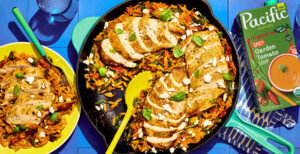 An image of prepared Skillet Tuscan Chicken with Orzo made with chicken, sun-dried tomatoes in olive oil, garlic, orzo pasta, white wine, Pacific Foods® Organic Spicy Garden Tomato Soup, baby spinach, feta cheese and basil.