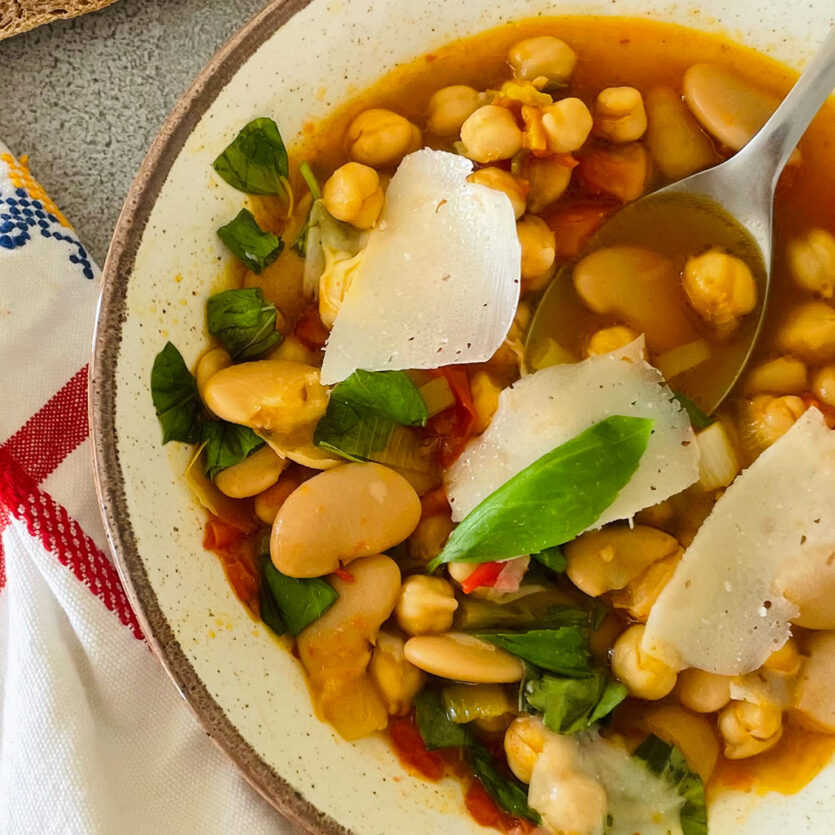 An image of prepared Summer Beans Stew made with Roma tomatoes, butter beans, chickpeas, Pacific Foods® Organic Vegetable Broth and basil.