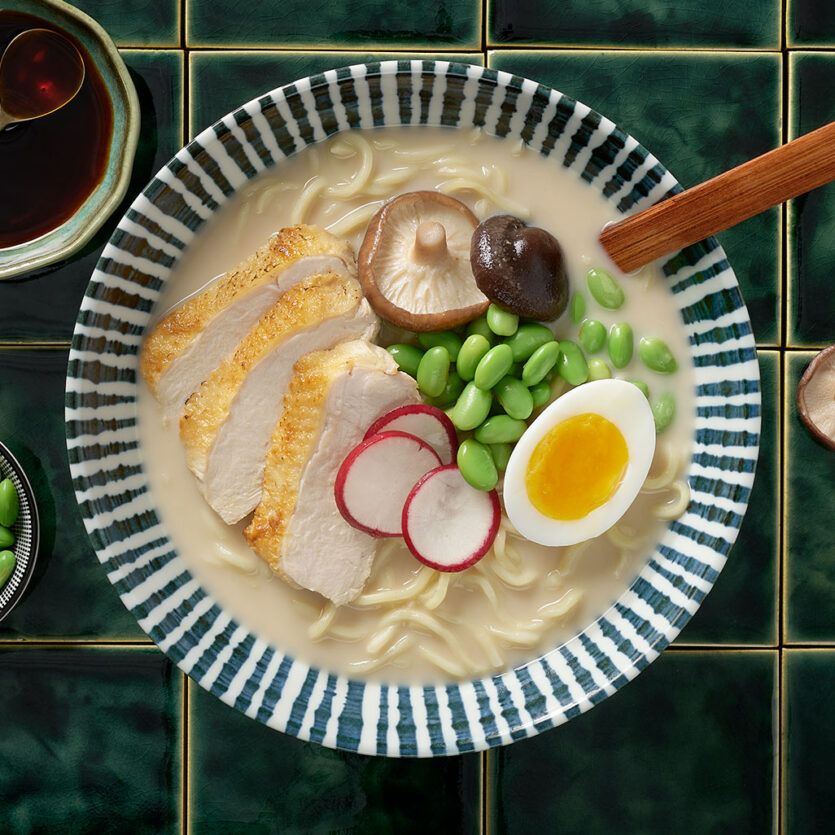An image of prepared Chicken Miso Ramen made with eggs, ramen noodles, Pacific Foods® Organic Chicken Miso Ramen Broth, chicken, edamame, corn, green onion and radish.