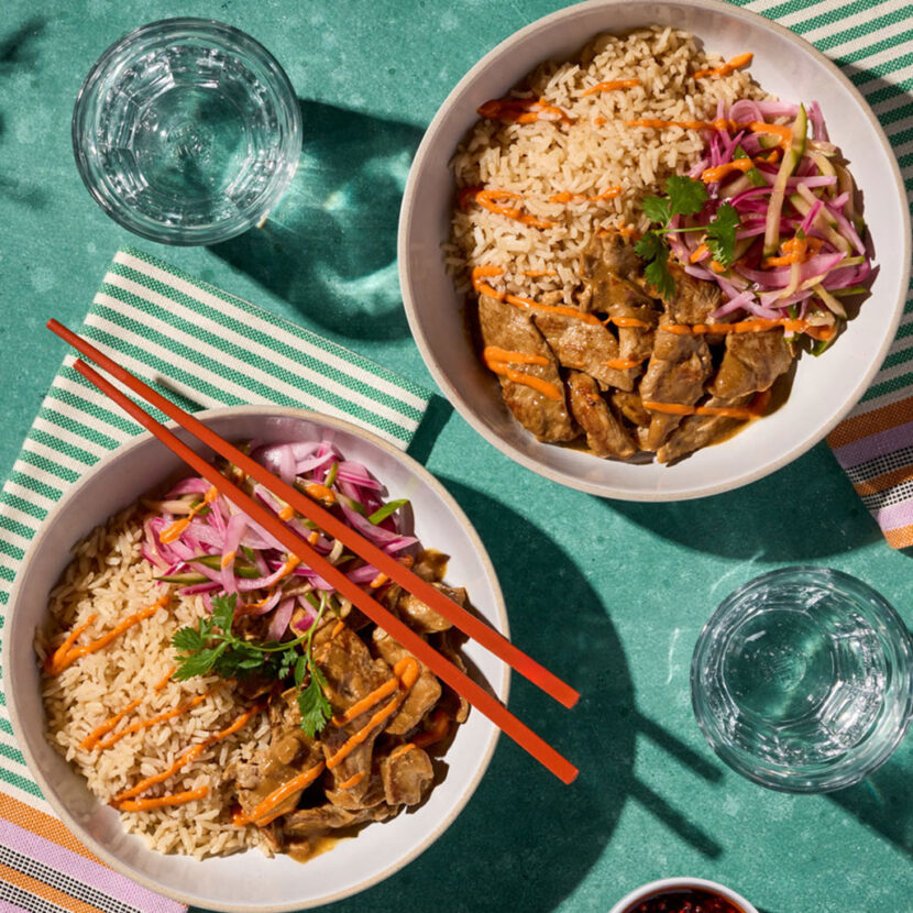 An image of prepared Japanese Pork Tonkotsu Rice Bowls made with pork tenderloin, onion, cucumber, rice, Pacific Foods® Organic Pork Tonkotsu Ramen Broth, mayonnaise and gochujang.