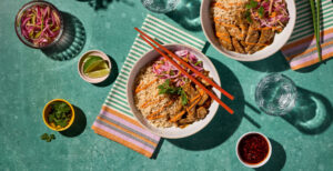 An image of prepared Japanese Pork Tonkotsu Rice Bowls made with pork tenderloin, onion, cucumber, rice, Pacific Foods® Organic Pork Tonkotsu Ramen Broth, mayonnaise and gochujang.