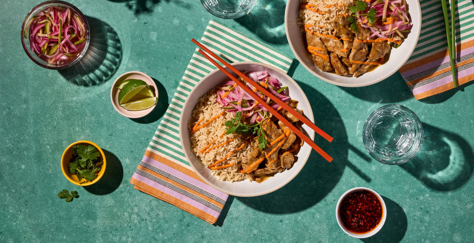 An image of prepared Japanese Pork Tonkotsu Rice Bowls made with pork tenderloin, onion, cucumber, rice, Pacific Foods® Organic Pork Tonkotsu Ramen Broth, mayonnaise and gochujang.