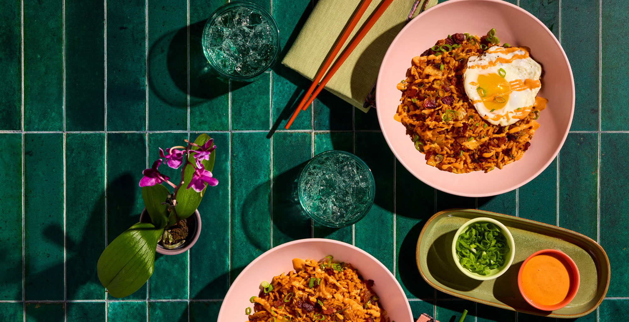 An image of prepared Kimchi Fried Rice with Fried Eggs and Gochujang Mayo made with Pacific Foods® Organic Pork Tonkotsu Ramen Broth, white rice, bacon, kimchi, gochujang and mayonnaise.